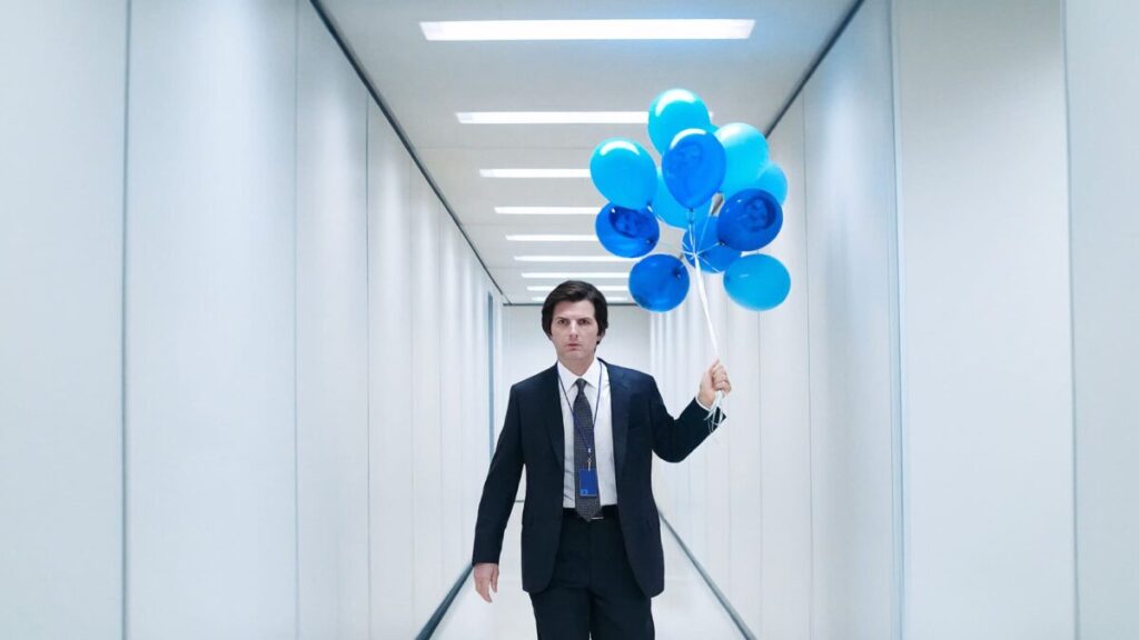 Adam Scott as Mark Scout dressed in a suit carrying blue balloons in an office corridor in the TV show, Severance: Season Two - Filmotomy