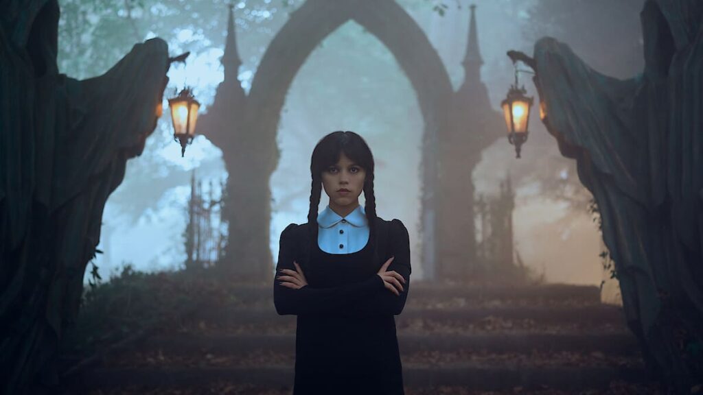 Jenna Ortega stands at her house entrance steps in the mist in Wednesday: Season Two - Filmotomy